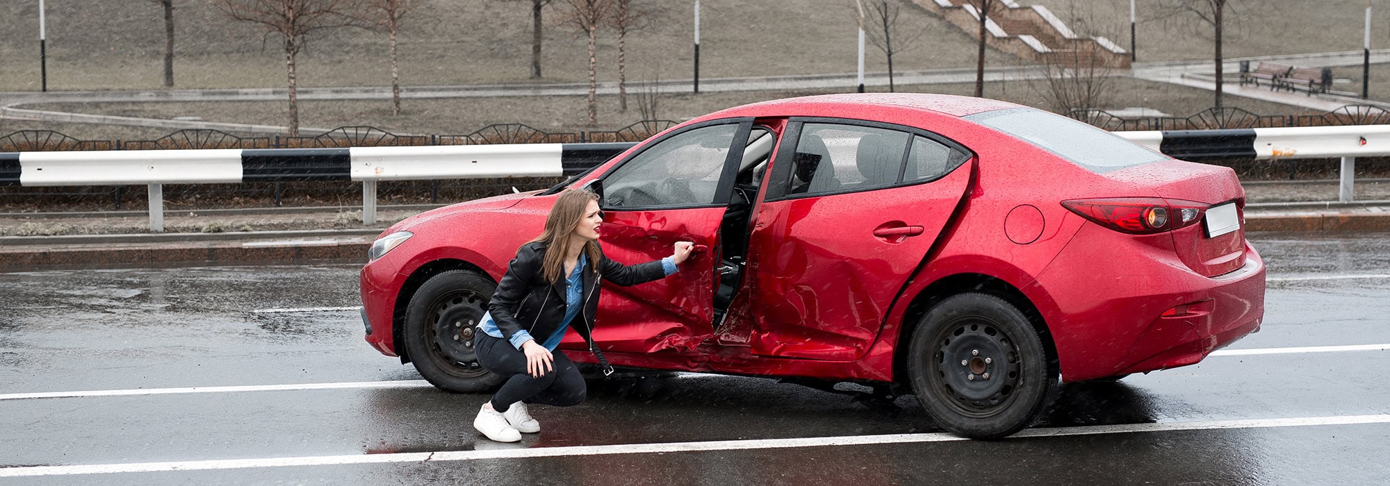 Woman by wrecked car after an accident