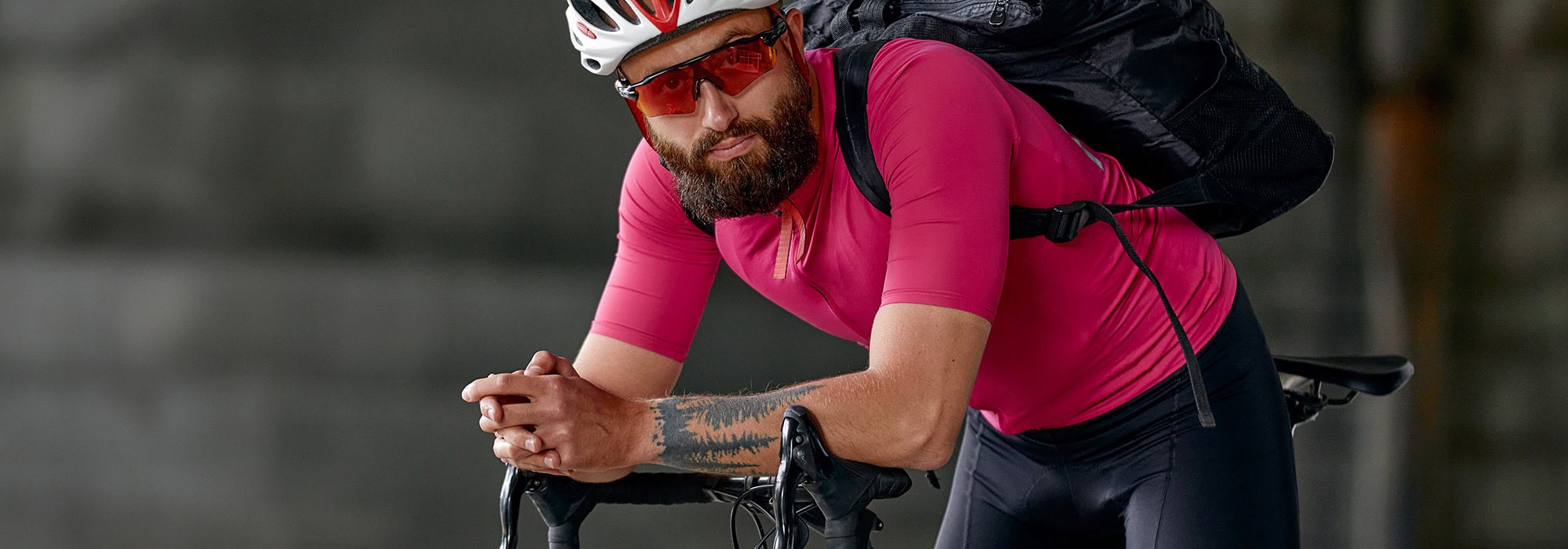 Male bicyclist in a pink shirt and helmet