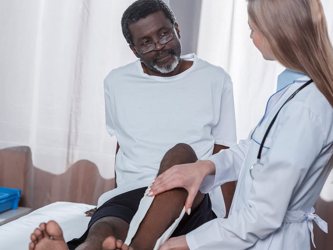 Doctor treating man with leg injury