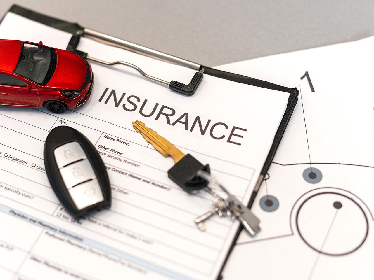 Insurance paperwork with a key fob