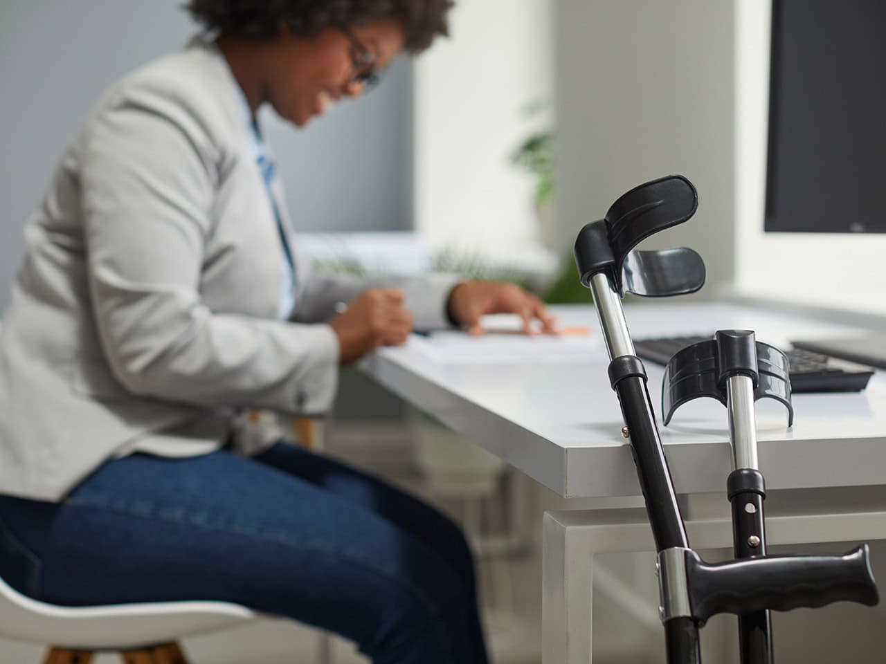 Disabled employee with crutches completing documents